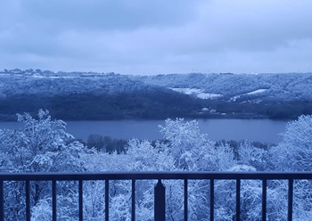 A view of a lake from a balcony in the snow